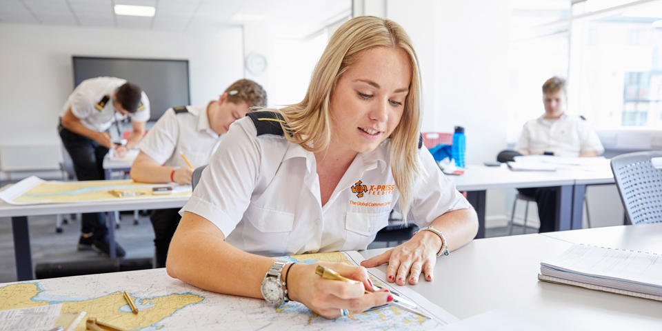 A female cadet plotting a route on a map